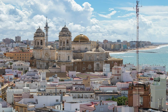 a view of a city with a large body of water in the background. Cadiz, Andalusia.