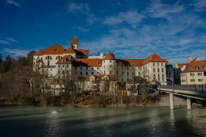 a bridge crossing over a river in front of a large building